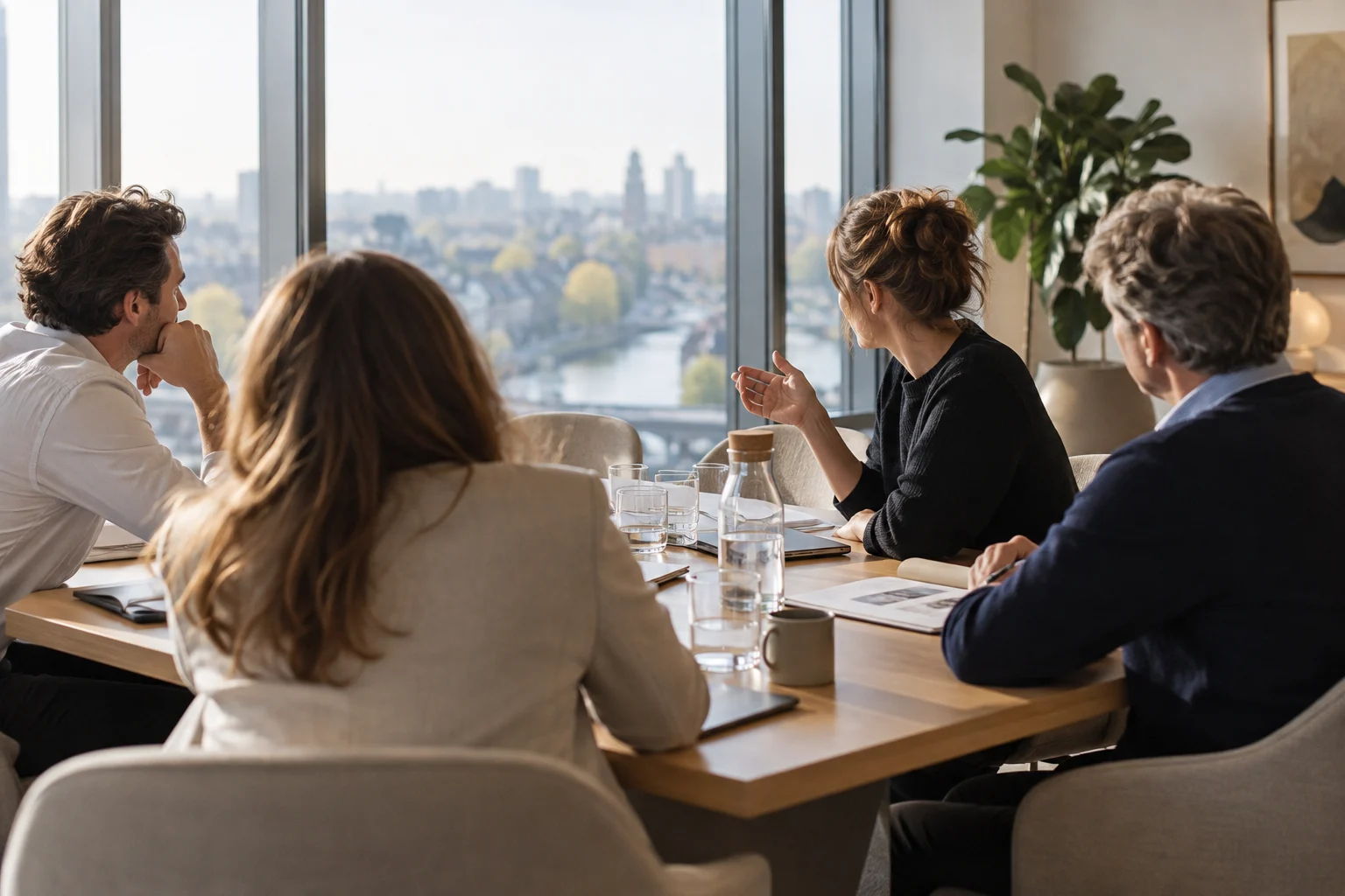 Anonieme collega's luisteren naar een medewerker tijdens overleg aan een boardroomtafel.